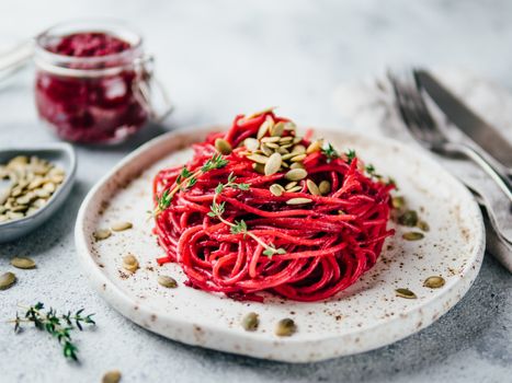 Beetroot pesto or hummus. Homemade beet pesto sauce in glass jar and fresh thyme on dark black background. Copy space for text. Ideas and recipes for healthy vegetarian detox diet food