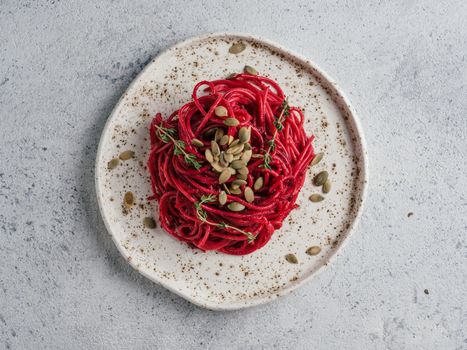 Beetroot pesto or hummus. Homemade beet pesto sauce in glass jar and fresh thyme on dark black background. Copy space for text. Ideas and recipes for healthy vegetarian detox diet food