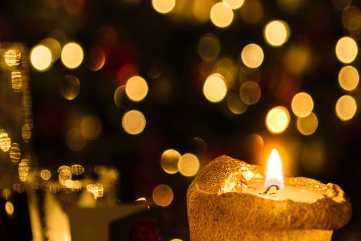 Christmas candle against colorful blur background christmas tree