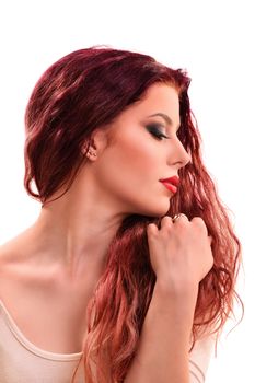 Sensual profile portrait of a beautiful redhead young woman with smoky make up holding her hair, isolated on white background.