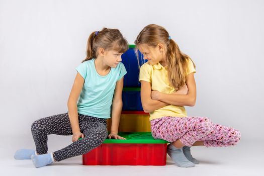 Two girls quarreling, turned to each other with a displeased face