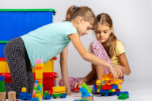 Two girls collect figures from the designer