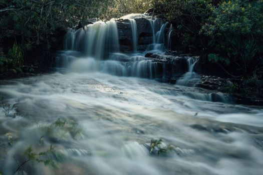 Raging waters of Kellys Creek flowing over the top of Kellys Falls and fast flowing along the rocks to a second sheer drop 35m into the valley