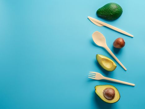 Avocado Seeds Biodegradable Single-Use Cutlery. Bioplastic - Great alternative to plastic disposable cutlery. Minimal concept on blue background. Copy space for text or design