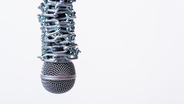 Chain on microphone with copy space on white background, Human rights day concept