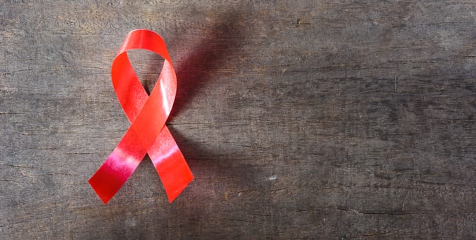 Red Ribbon Support HIV, AIDS on wooden background and copy space for use