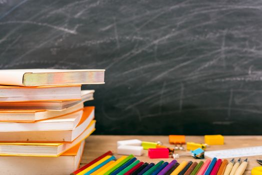 Classroom, with stack books on table have blackboard and chalkboard on background, back to school concept