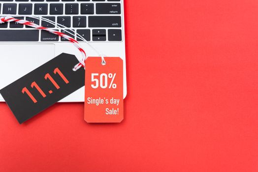 11.11 black tag online shopping Single's day sale text red tag label on laptop computer, with copy space red background