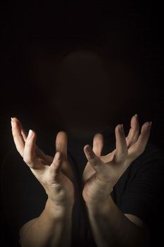 Outraged woman's hands with spread fingers on a black background