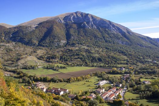 landscape of a sunny valley and mountain peaks as seen from the town of Opi, in Abruzzo national park, Italy