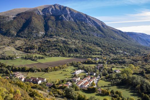 landscape of a sunny valley and mountain peaks as seen from the town of Opi, in Abruzzo national park, Italy