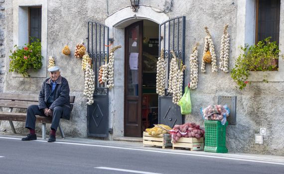 At Barrea - Italy - On october 2019 - Old man sitting outside a fruit shop