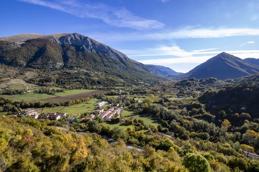 landscape of a sunny valley and mountain peaks as seen from the town of Opi, in Abruzzo national park, Italy