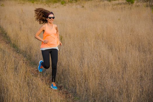 Shot of an attractive woman running outdoor on a meadow