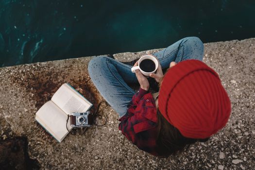 Beautiful woman enjoying her day in the lake with a mug of hot coffee