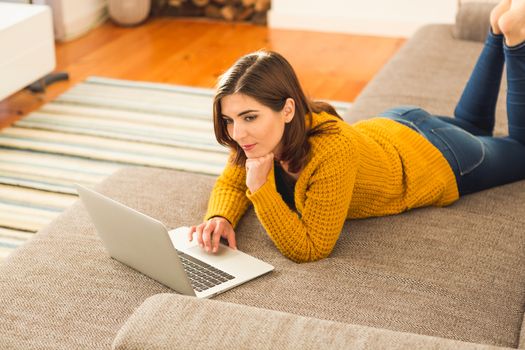 Beautiful woman working from the confort of home with her laptop