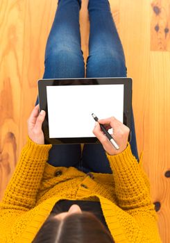 Beautiful woman sitting on the floor working with a tablet 