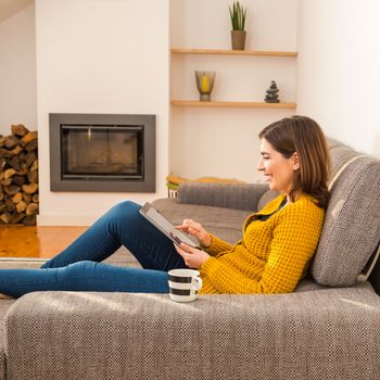 Beautiful young woman working with a tablet at home