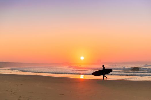 Surfer leaving the ocean after a long day of surf(