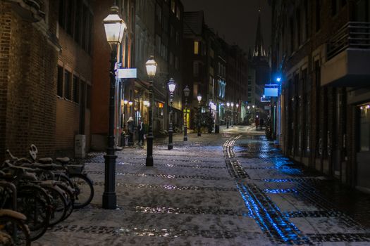 Snowy empty street at night in Aachen, Germany - lights and reflections