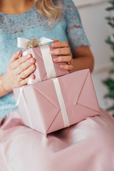 Hands holding gift present. Closeup of Female hands giving the gift in the New Year interior