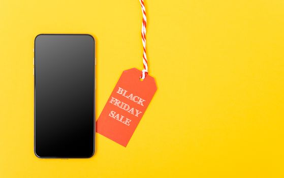 Internet Online shopping,  Black Friday Sale red tag and Smartphone blank screen on yellow background