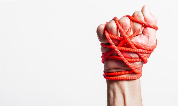 Red Rope on fist hand on white background, Human rights day concept with copy space for use