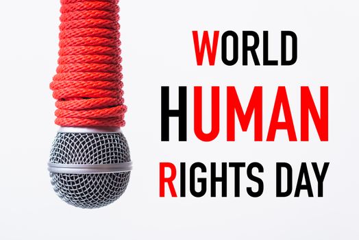 Red Rope on microphone with WORLD HUMAN RIGHTS DAY text on white background, Human rights day concept