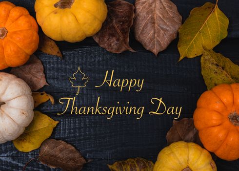 Fall Thanksgiving and Halloween pumpkins and dry leaves on wooden background, top view shot