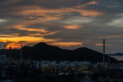 The Oil Or Gas Refinery At Sunset. A silhouette of an oil or gas industrial refinery at sunset with a colourful sky behind