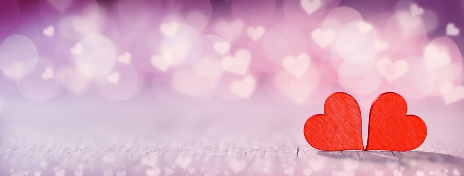 Two handmade wooden red hearts on beautiful bokeh background. Vintage style. Love Valentine's Day concept.