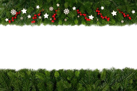 Christmas Border frame of tree branches and red berries and wooden decor on white background with copy space isolated