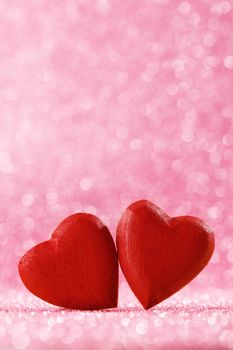 Two handmade wooden red hearts on beautiful bokeh background. Vintage style. Love Valentine's Day concept.