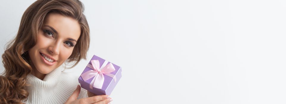 Smiling cute girl with pink christmas gift box