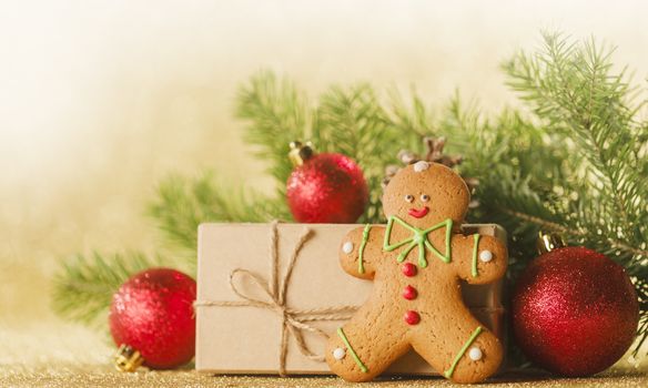 Christmas toys, decorations, present gift box wrapped in kraft paper on golden glitter background, copy space