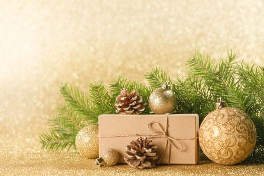 Christmas toys, decorations, present gift box wrapped in kraft paper on golden glitter background, copy space