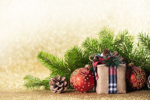 Christmas toys, decorations, present gift box wrapped in kraft paper on golden glitter background, copy space