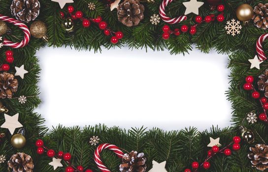 Christmas Border frame of tree branches on white background with copy space isolated, red and white decor, berries, stars, cones