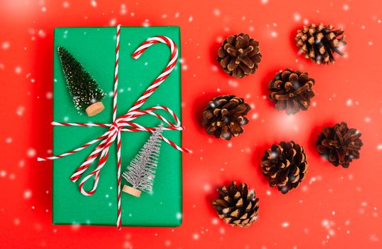 New Year, Christmas Xmas holiday composition, Top view gift green box, clews of rope and green fir tree branch on red background with copy space