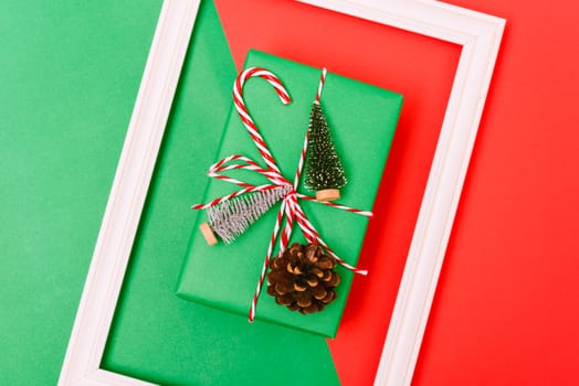 New Year, Christmas Xmas holiday composition, Top view gift green box, clews of rope, green fir tree branch on red and green background with copy space