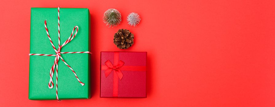 New Year, Christmas Xmas holiday composition, Top view green and red gift box and green fir tree branch on red background with copy space