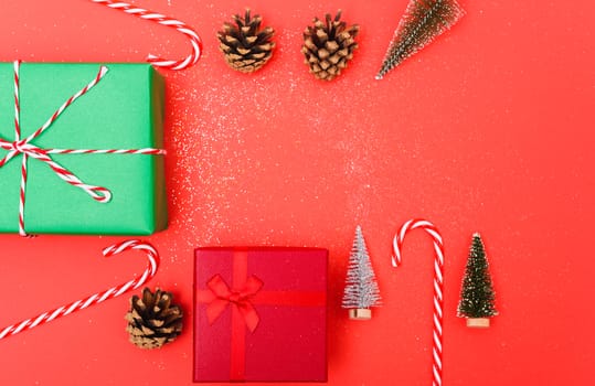 New Year, Christmas Xmas holiday composition, Top view green and red gift box, clews of rope, green fir tree branch on red background with copy space