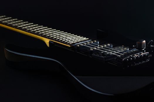 Black electric guitar in darkness. Concept of rock music style.