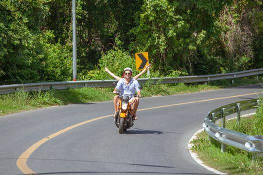 Happy couple on a scooter at summer vacation