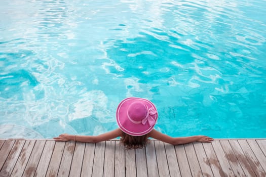 Beautiful woman relaxing at swimming pool at tourist resort