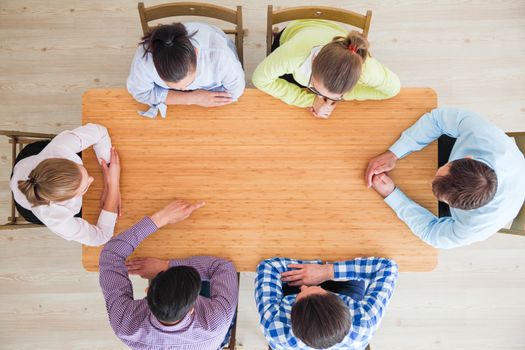 Hipster business teamwork brainstorming planning meeting concept, people team sitting around the table and pointing at copy space