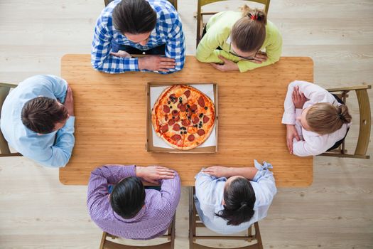 People hands grabbing pizza from delivery box, top view