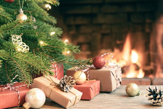 Gifts under the Christmas tree in the room with a fireplace on Christmas eve.