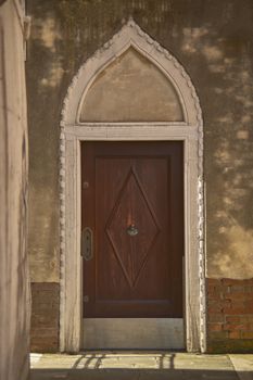 Ancient wooden door with a characteristic design belonging to a historic building dating back to the Middle Ages.