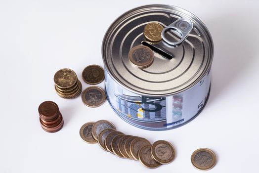 TFinancial risk and safety concept.he concept of money. A piggy bank in the form of a tin can and, next to the piggy bank, money bills and coins are laid out.